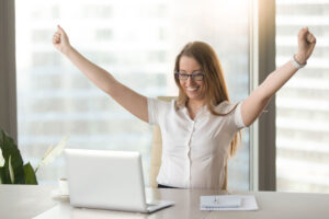 a business owner in a sky rise office celebrating how she has learnt how to boost online sales