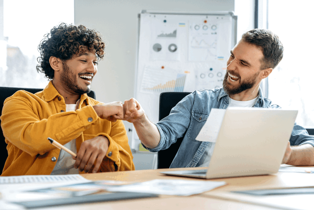 team members fist bumping after creating a marketing brief