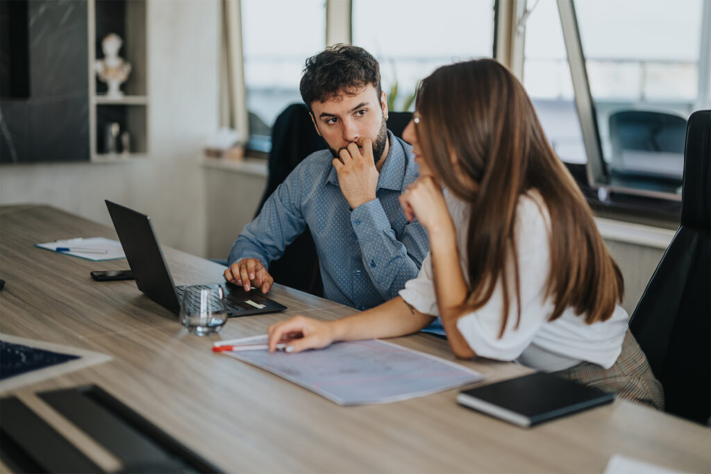 two marketers having an in-depth conversation about seo for e-commerce at their desk