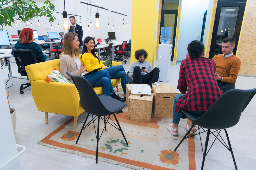 a team of young colleagues chatting in a shared office