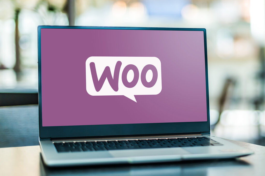 an open laptop on a surface with the WooCommerce logo on the screen