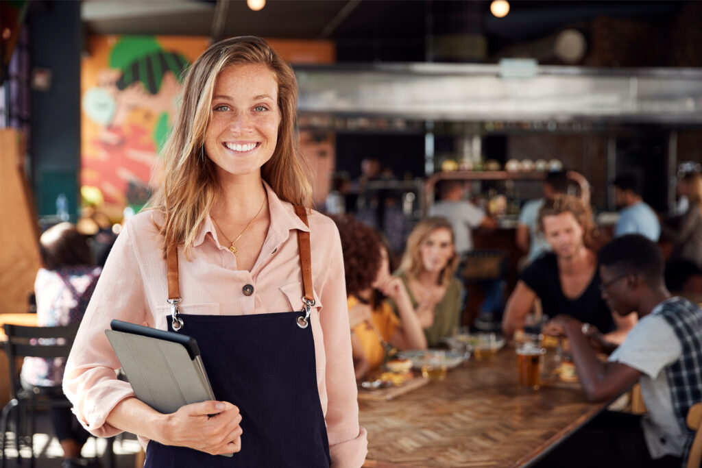 a business owner in her restaurant serving loyal return customers