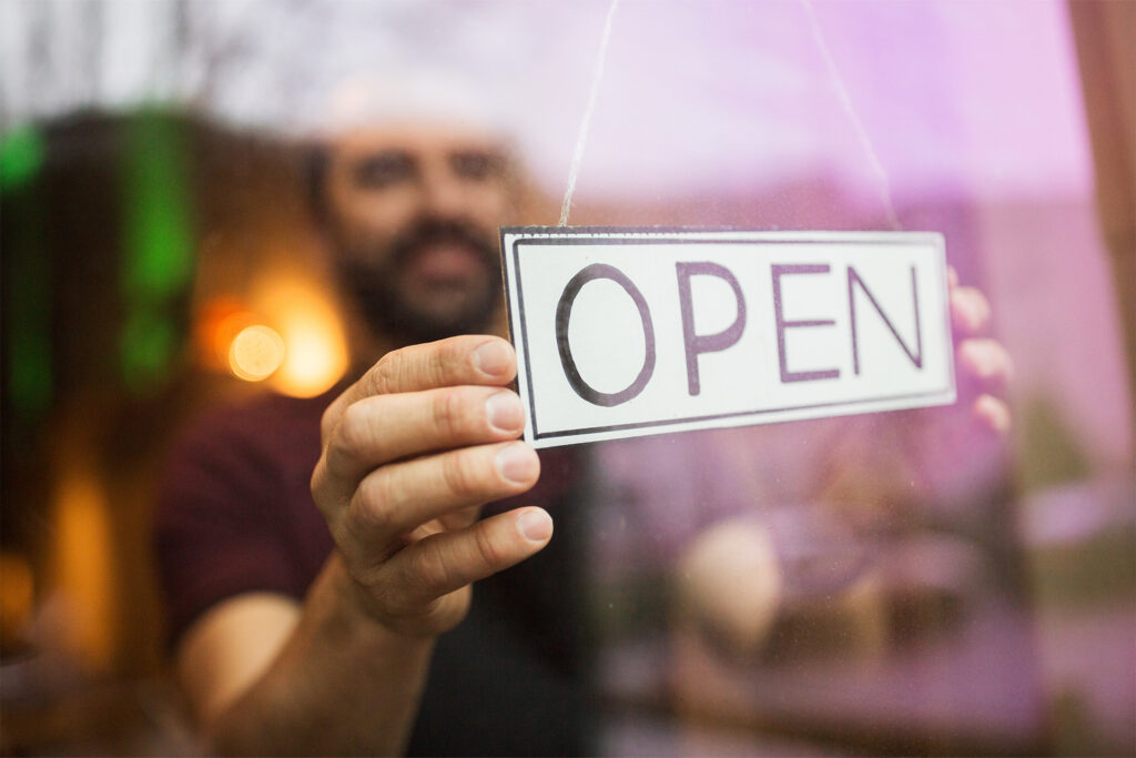 bartender with open banner at bar window