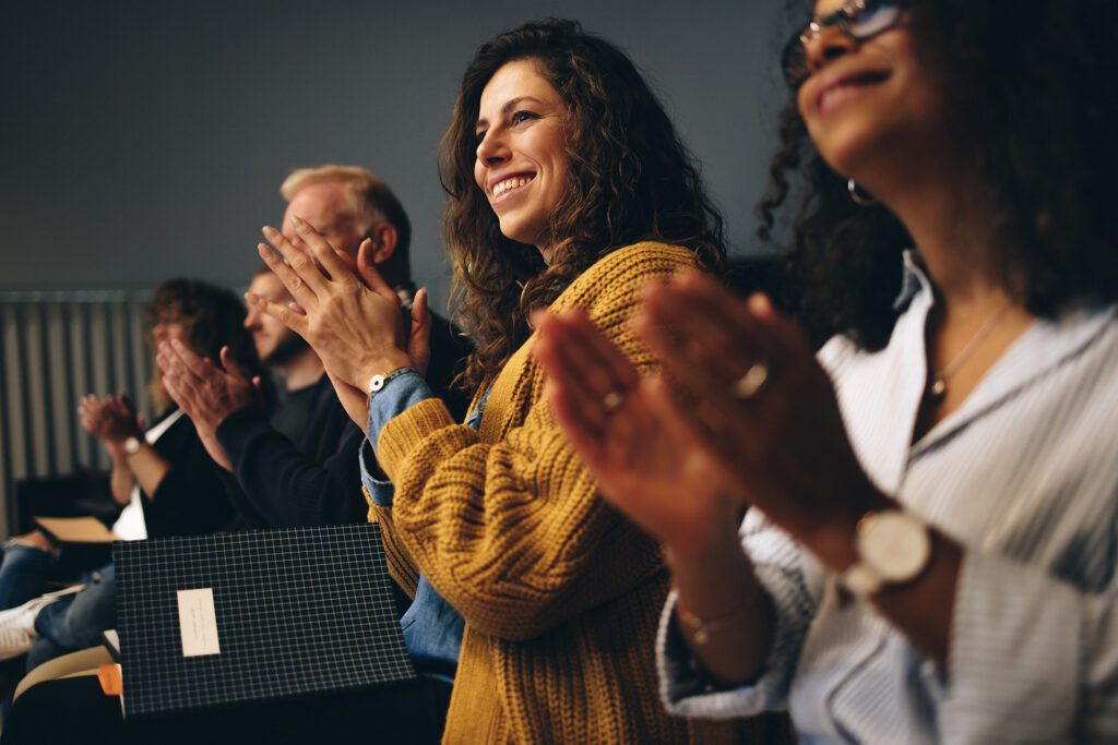 a full and applauding audience in a seminar hall