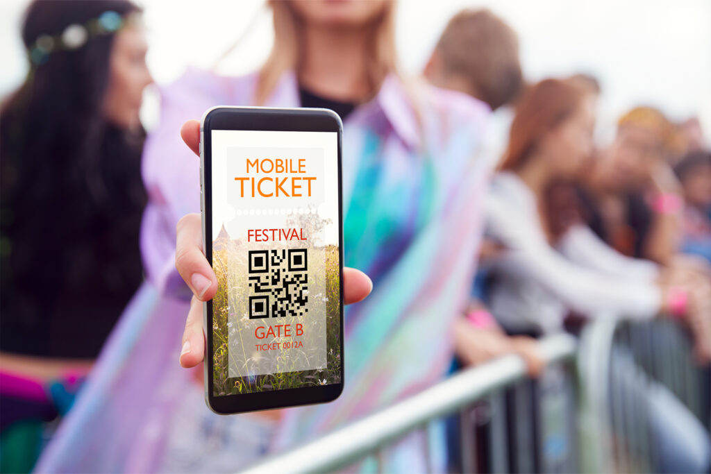 a woman at a musical festival showing a mobile e-ticket