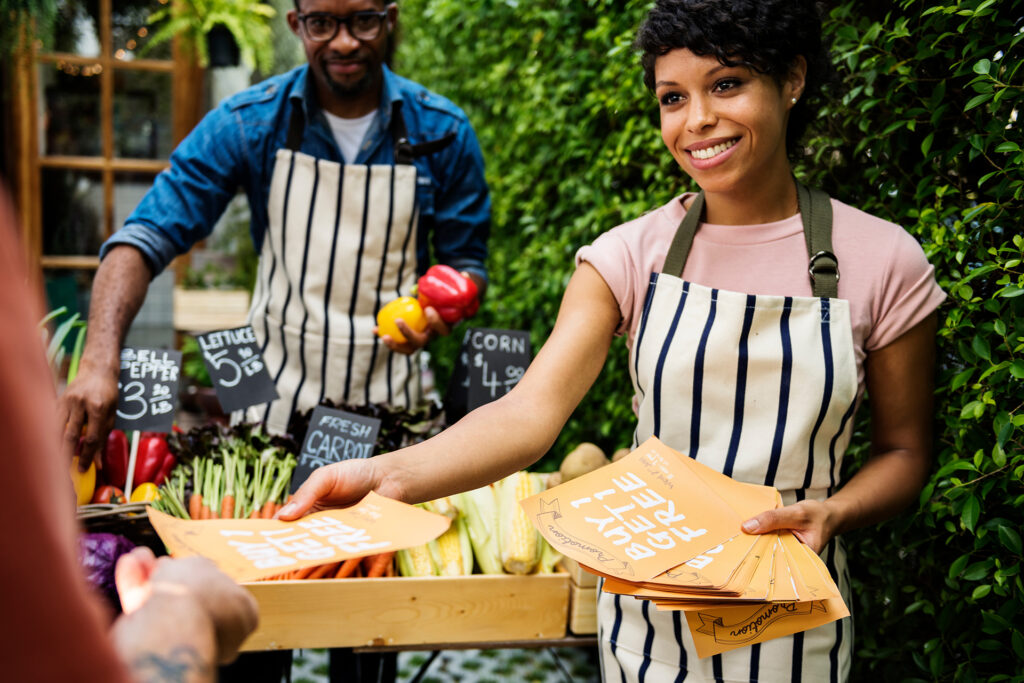 greengrocers handing out promotional leaflets with promo codes