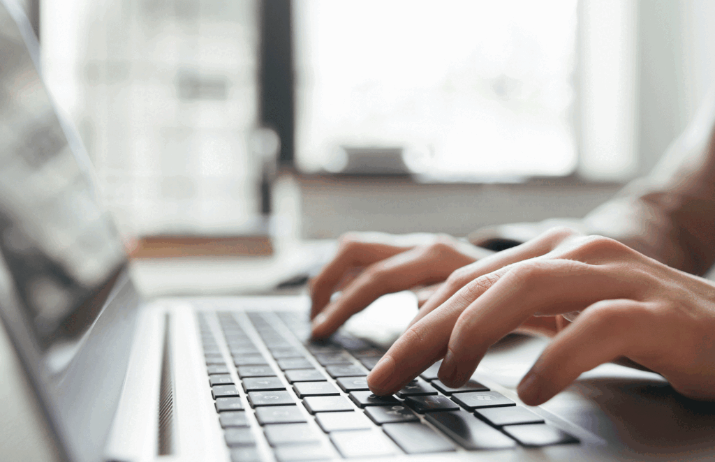 a content writer typing at a laptop
