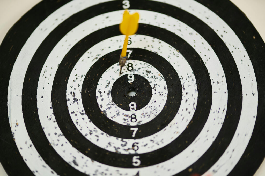 a bullseye with a yellow dart close to the middle representing successful business copywriting