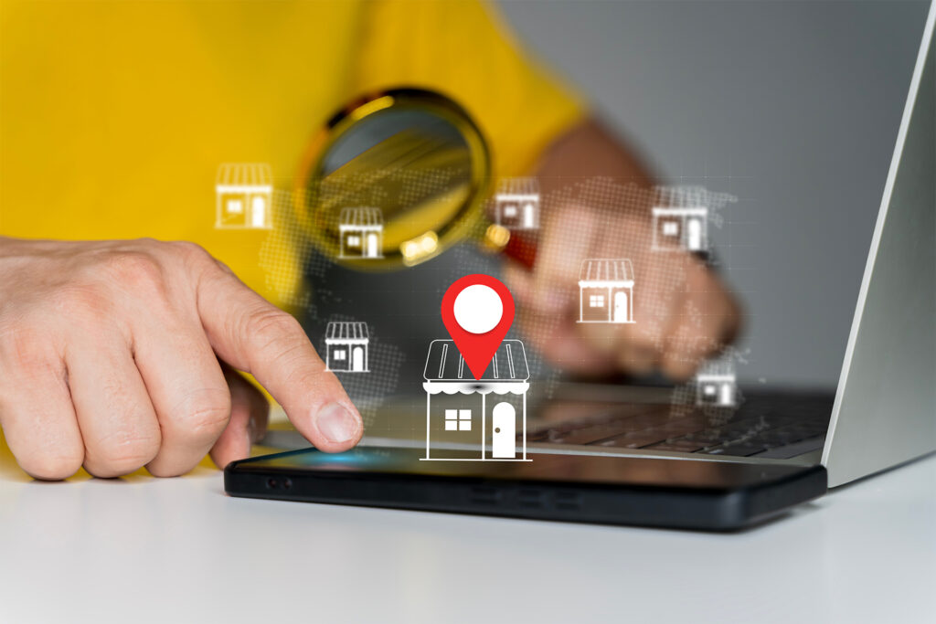 a marketer with a magnifying glass pointing to a virtual shopfront on a mobile device