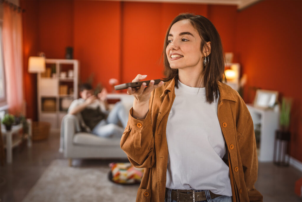 a young white woman using voice search in her living room