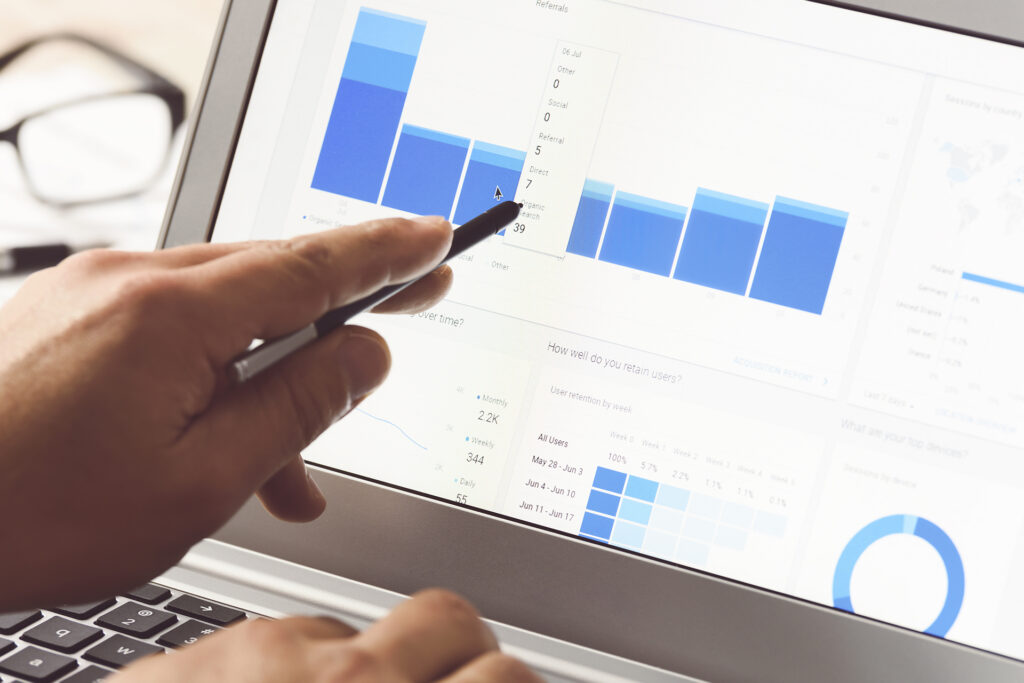 a marketer on their laptop pointing to their social media analytics for a fashion brand