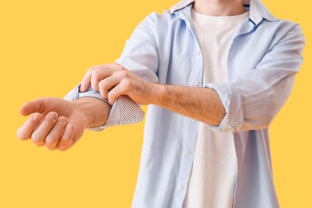 a guy rolling up his sleeves in anticipation in front of a yellow background