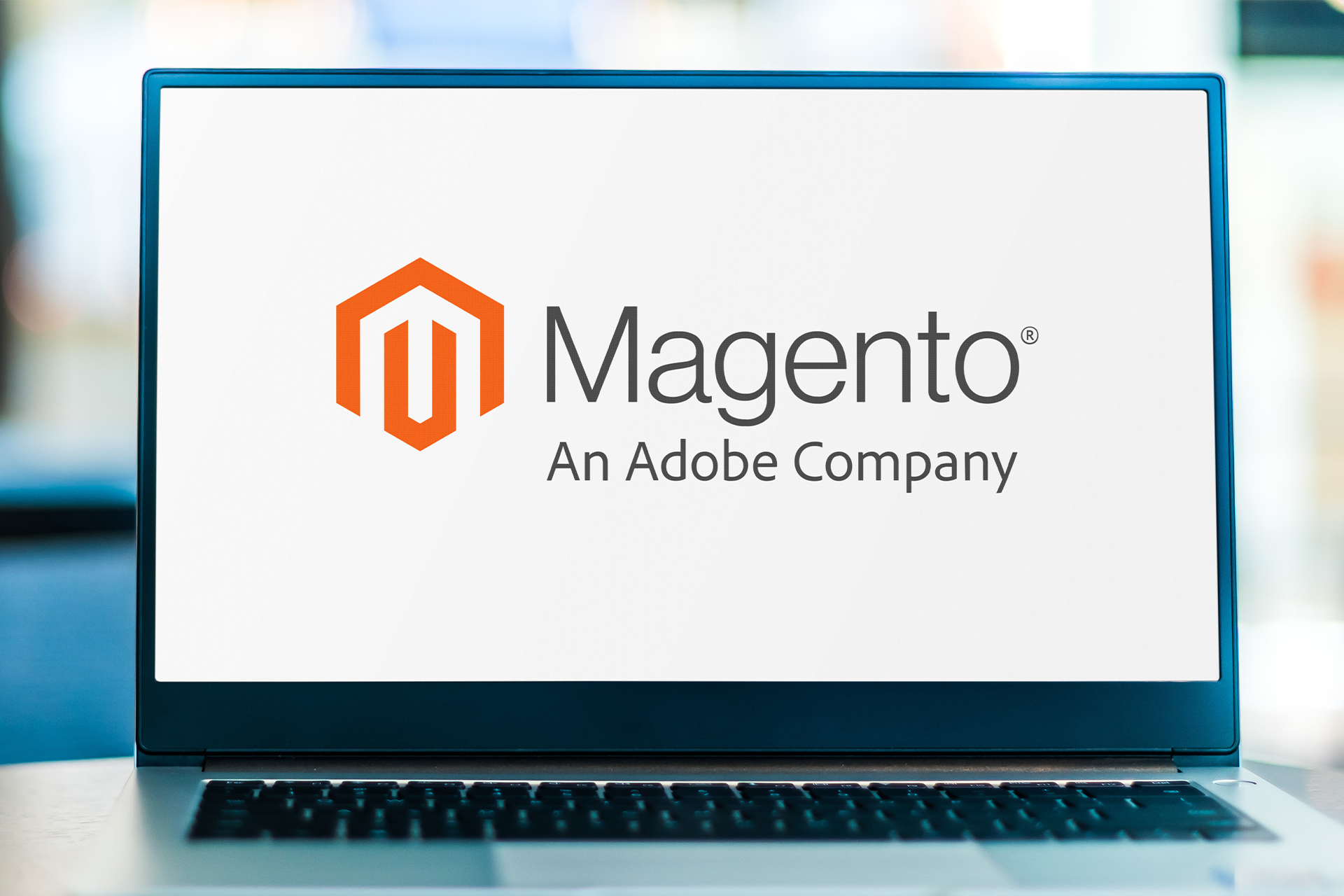 Laptop computer displaying the logo of Magento an Adobe Company