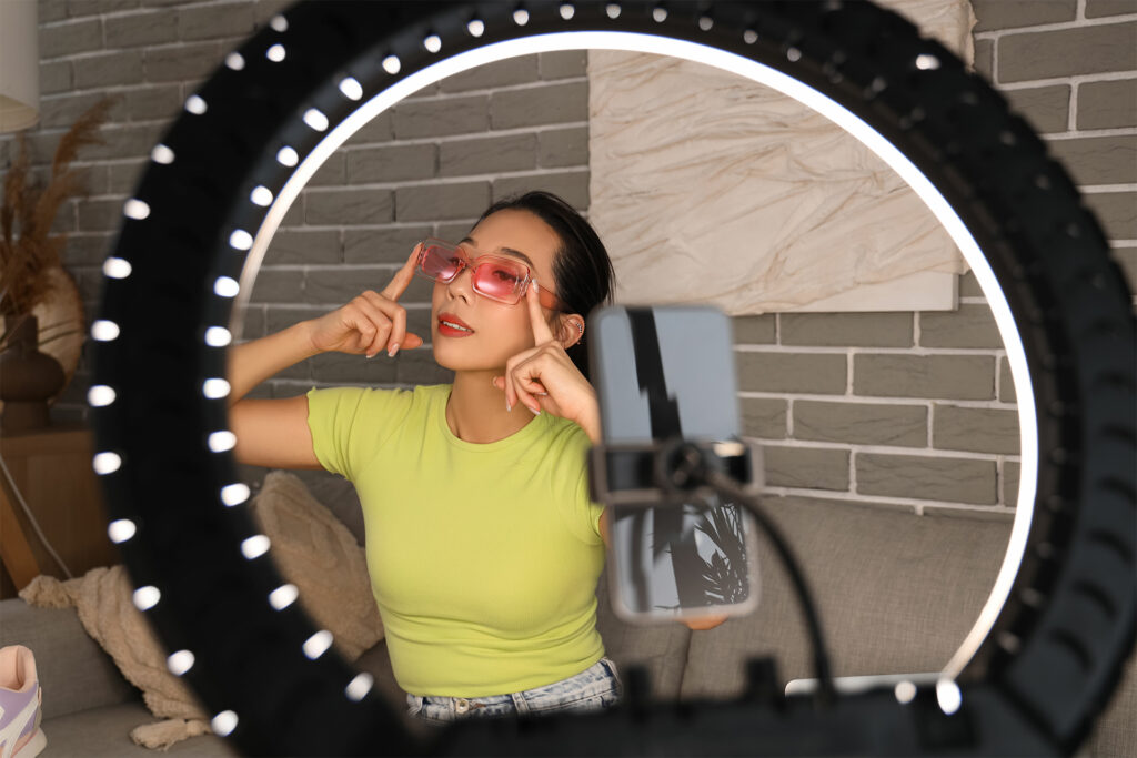 a female influencer trying on sunglasses while filming social media content for a fashion brand