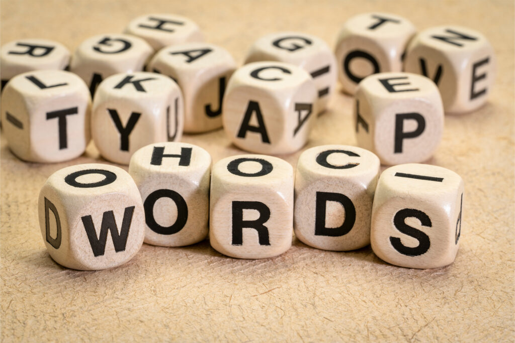 a handful of six sided dice with letters on each face some spelling out words