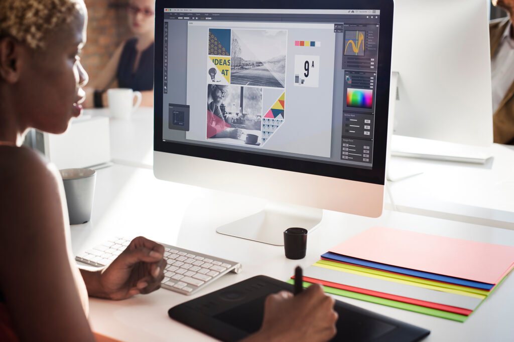 a graphic designer working on a small business brand concept on a laptop and tablet