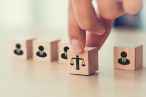 ethical advertising represented by wooden blocks featuring business people and one with a scale